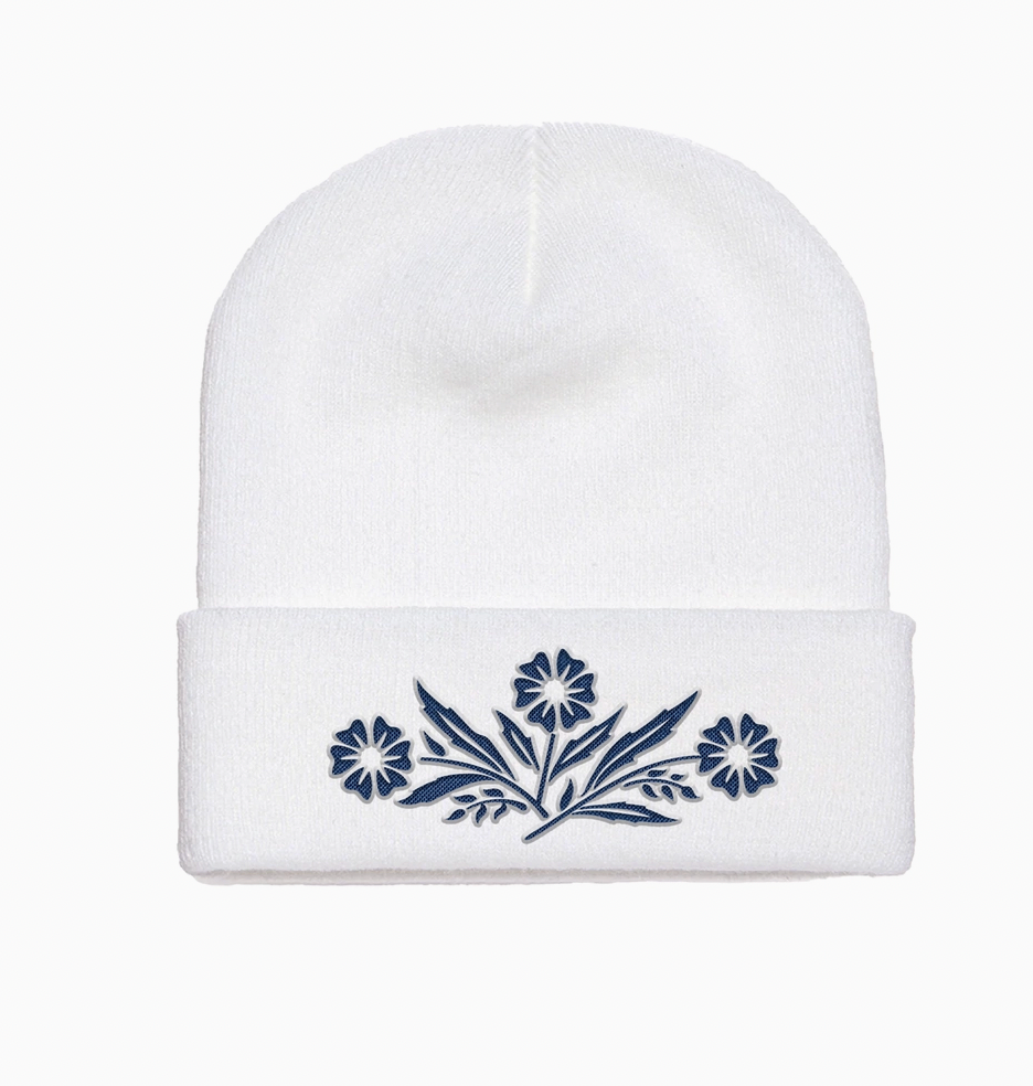 White beanie with blue floral embroidery on a white background