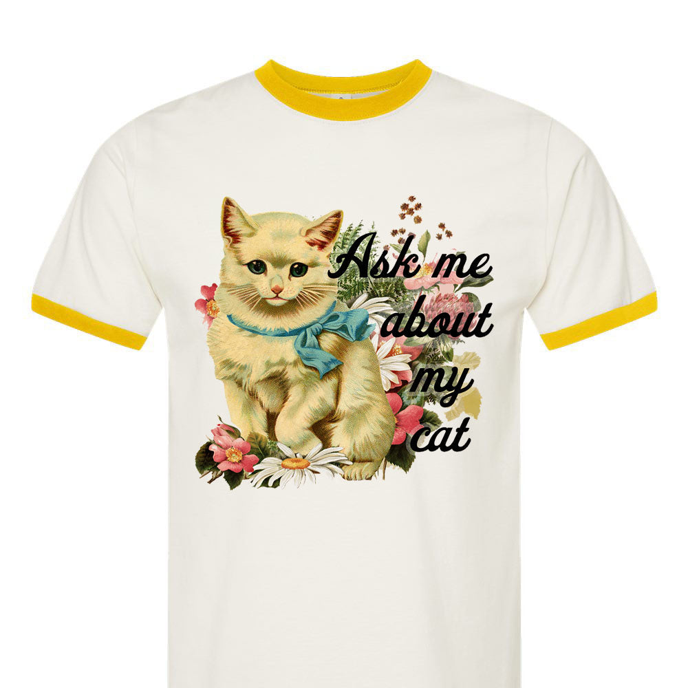White t-shirt with yellow trim featuring a cat graphic and text on a white background