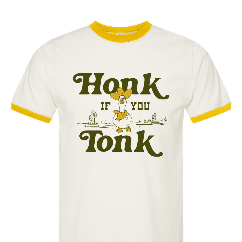 A white ringer tee with yellow trim, featuring a graphic that says 'Honk if you Tonk' with a cartoon goose wearing a cowboy hat.