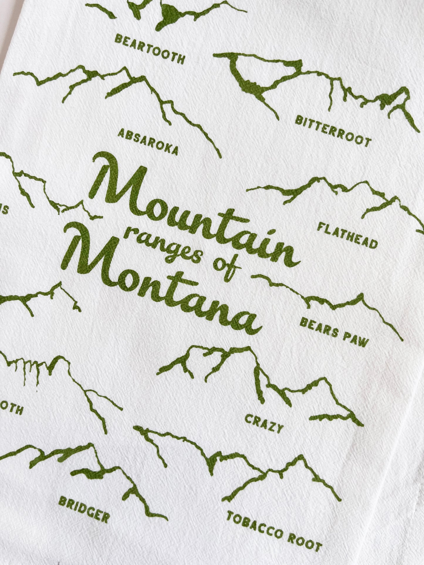 cotton tea towel with drawings of the mountain ranges of montana green screen print fun modern kitchen home decor coin laundry montana