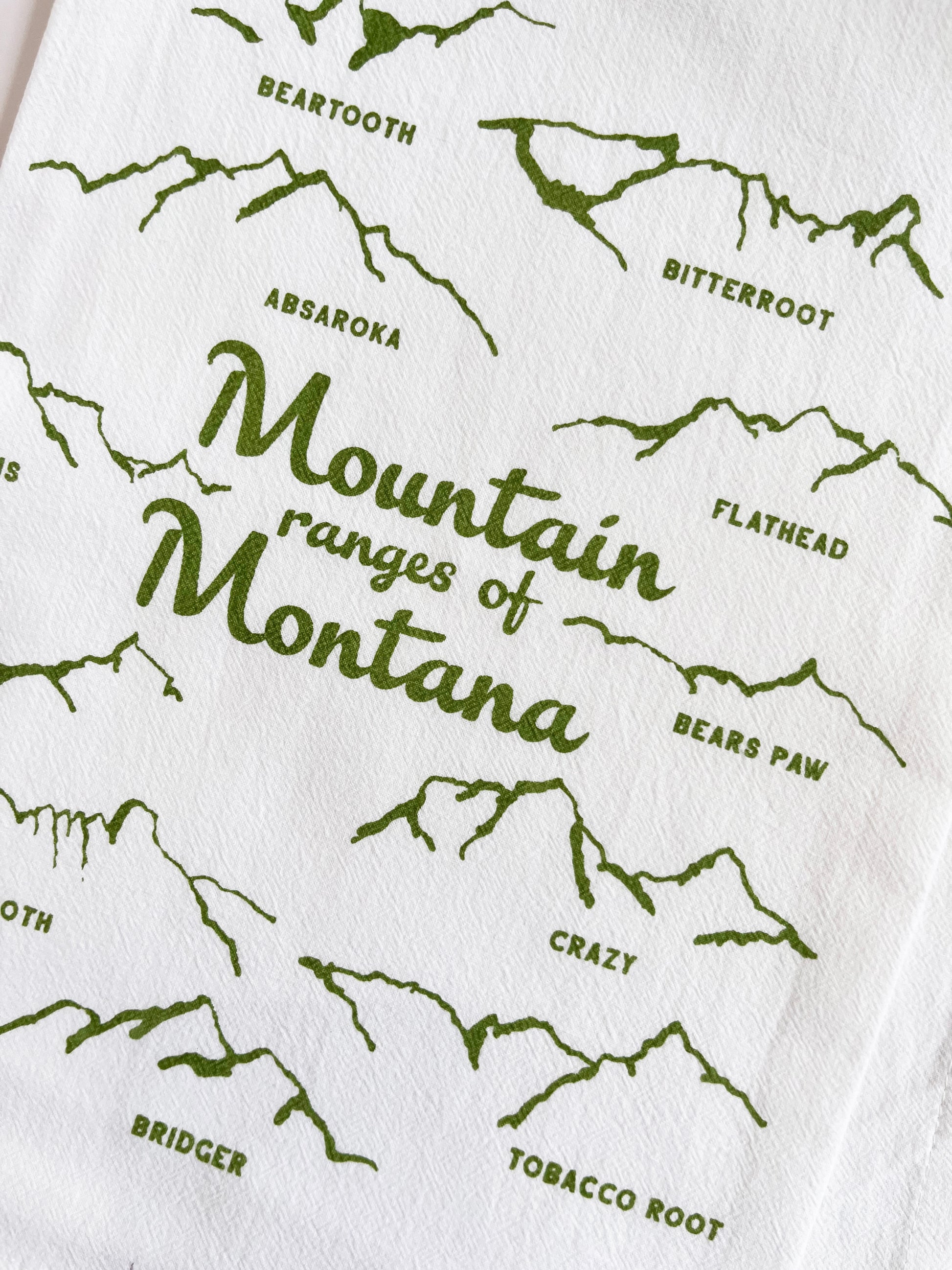 cotton tea towel with drawings of the mountain ranges of montana green screen print fun modern kitchen home decor coin laundry montana