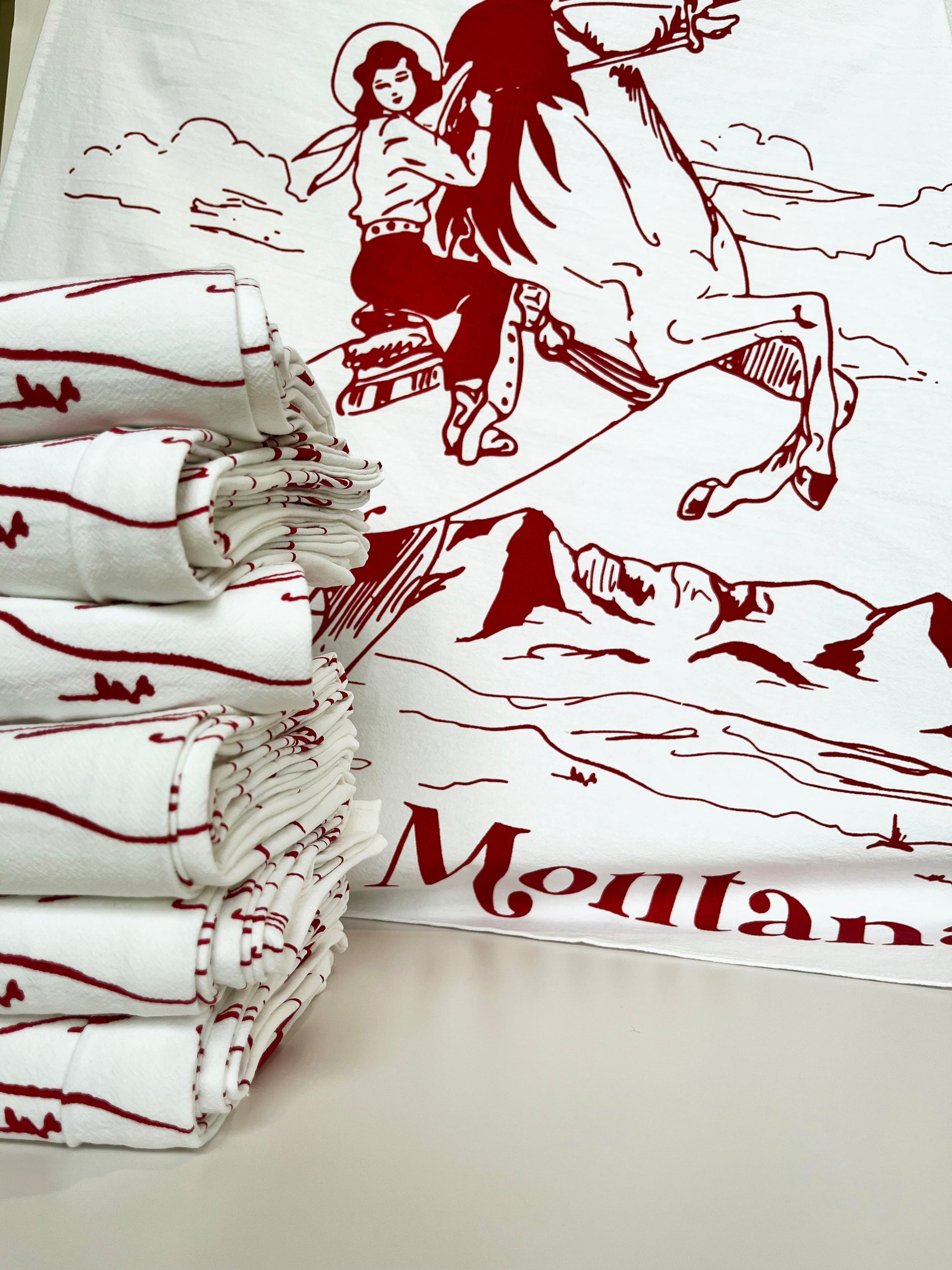 fun montana souvenir tea towel cowgirl riding horse theres no place like montana red burgundy white screen print  all over design hand drawn illustration cute towels coin laundry montana
