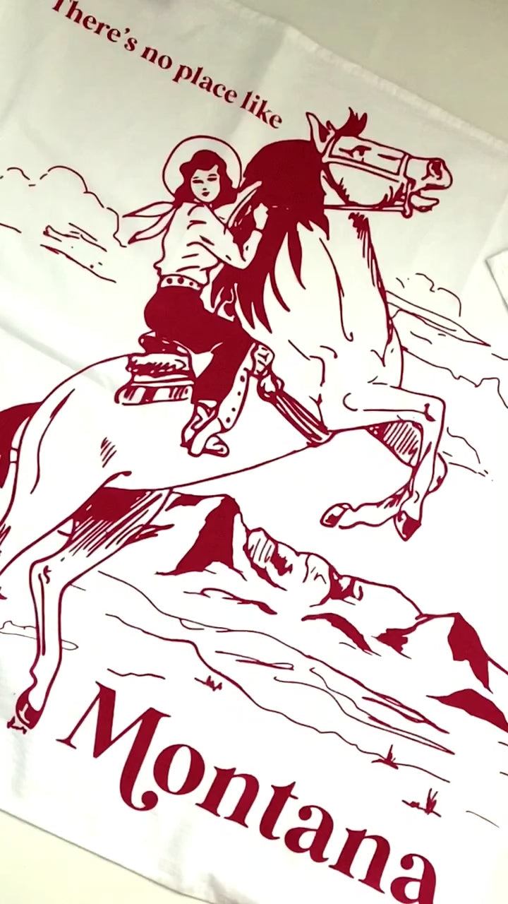 decorative cotton kitchen towel with all over screen print of cowgirl riding horse text says theres no place like montana red print coin laundry unique fun cotton dish towels