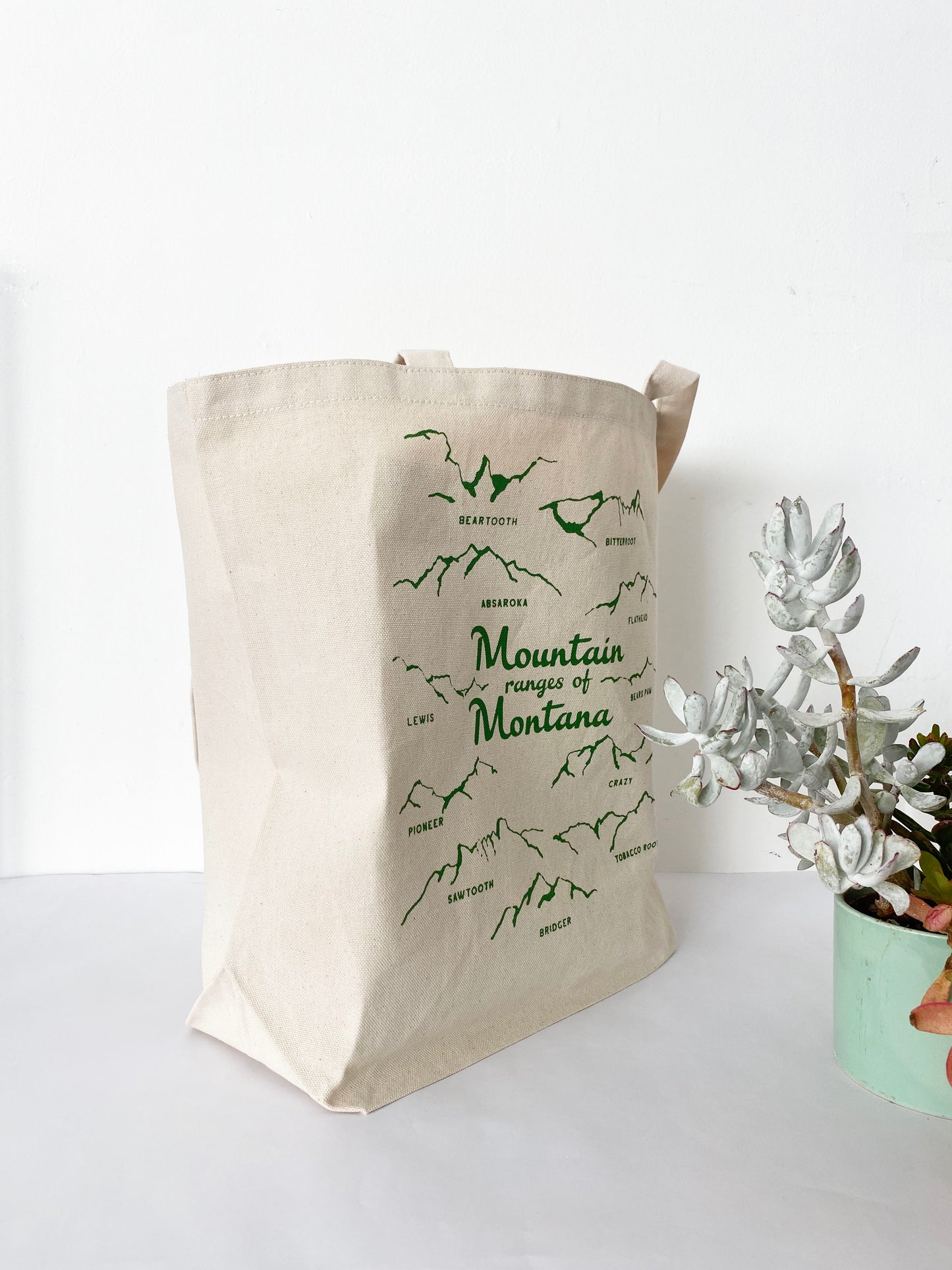 heavy duty cotton canvas tote bag with names of mountain ranges of montana screen print green hand drawn coin laundry souvenir montana screen print earth friendly