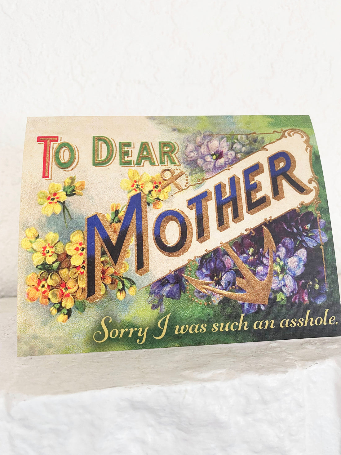 Victorian style card with purple and yellow flowers and an anchor with the text Dear Mother Sorry I was such an asshole
