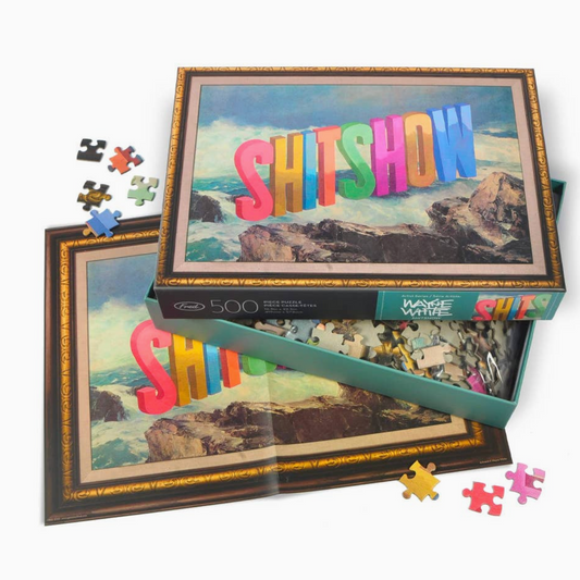 Jigsaw puzzle with 'SHITSHOW' text and ocean view packaging on a white background