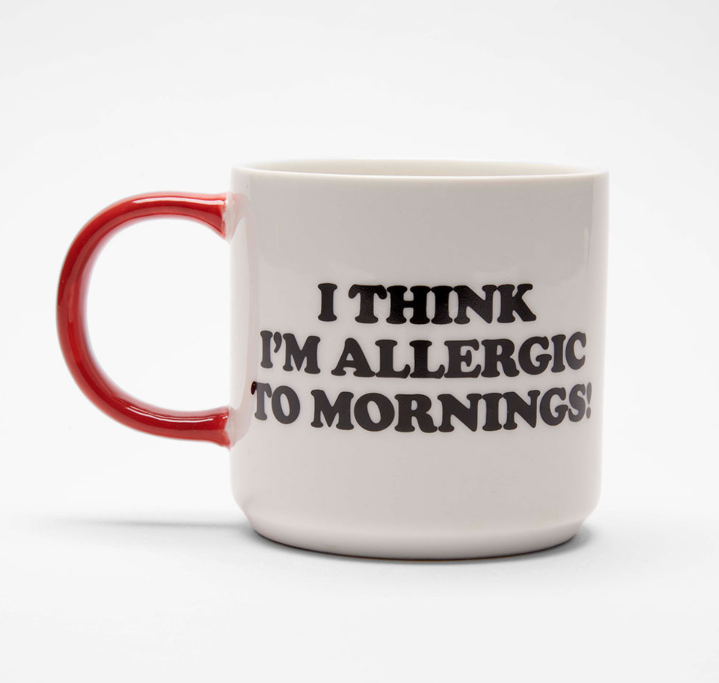 A white ceramic coffee mug with a glossy red handle and black printed text that reads 'I THINK I'M ALLERGIC TO MORNINGS!' on a clean white background.