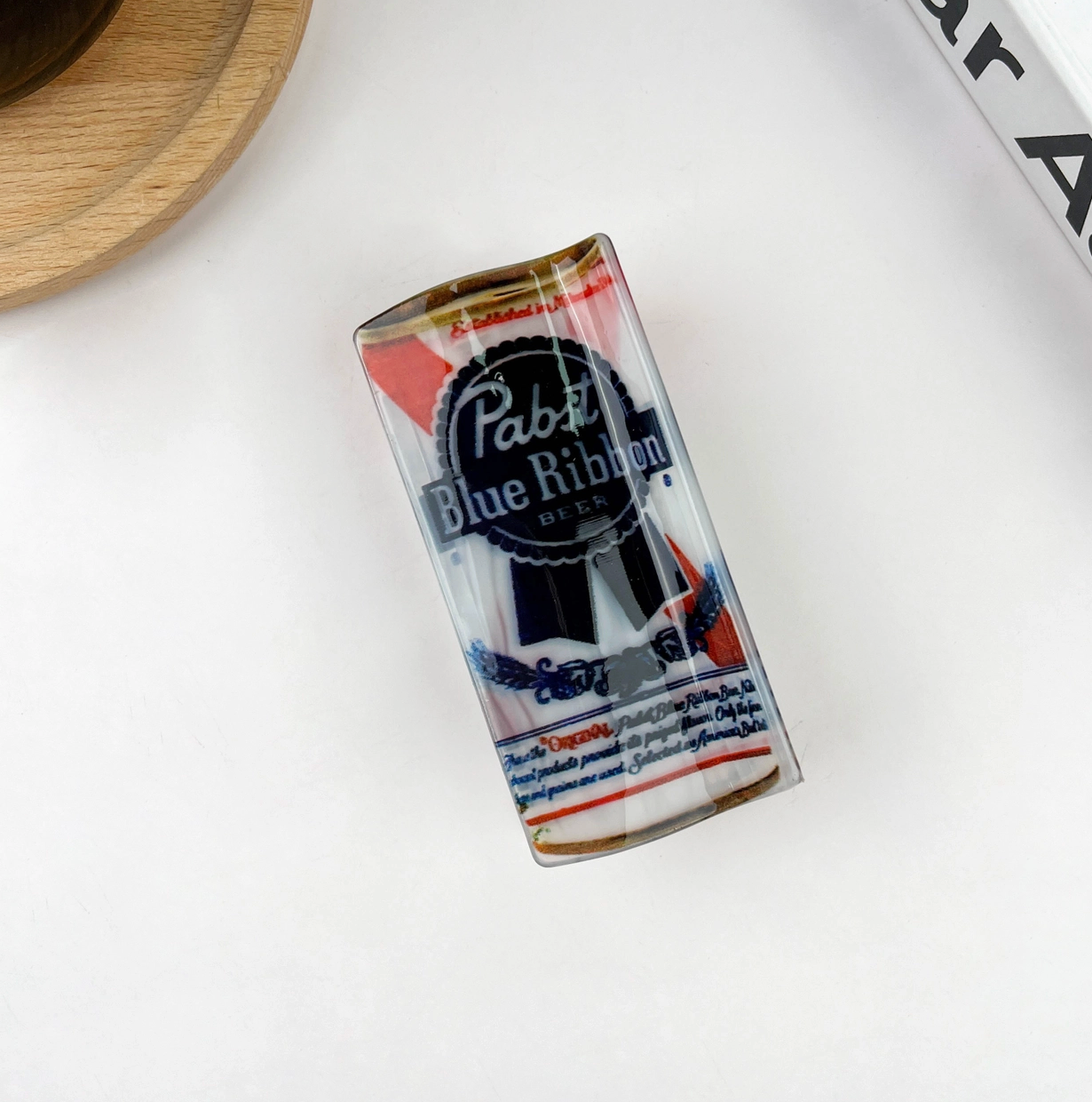 Pabst Blue Ribbon hair claw clip on a white surface