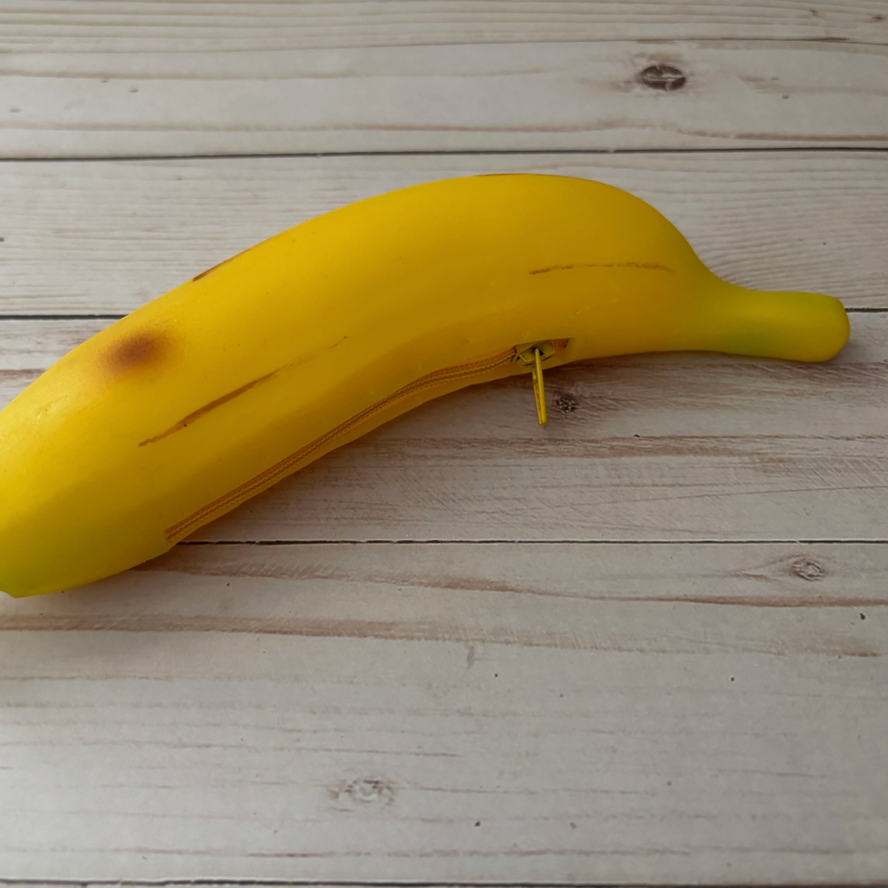 Yellow banana coin purse on a wooden surface