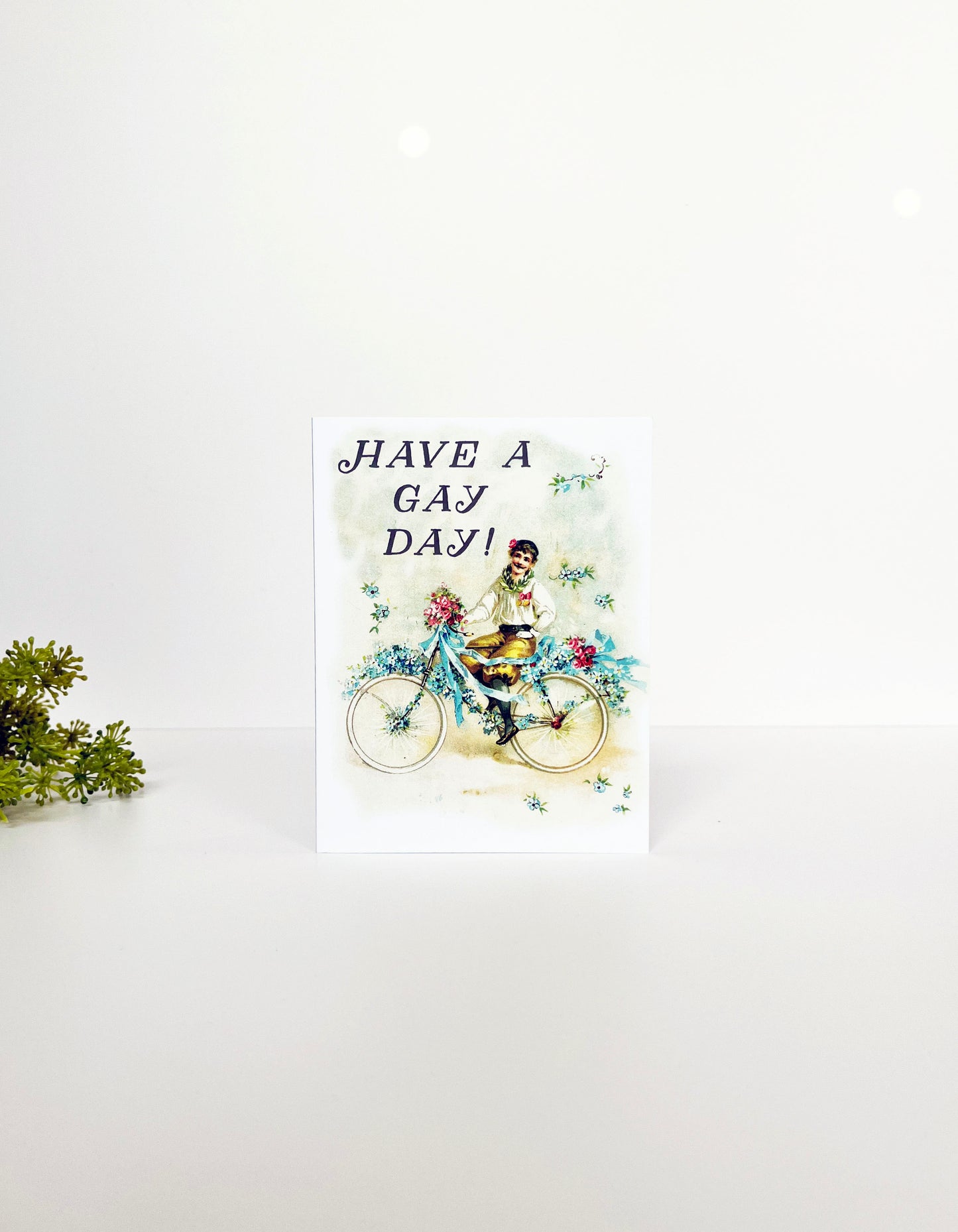 have a gay day all occasion blank inside greeting card note card mail happy event congrats congratulations just saying hello white background pastel colors flamboyant vintage man riding bike flowers ribbons celebrate celebration party surprise birthday retirement new car house lbgtq pride ally coin laundry 