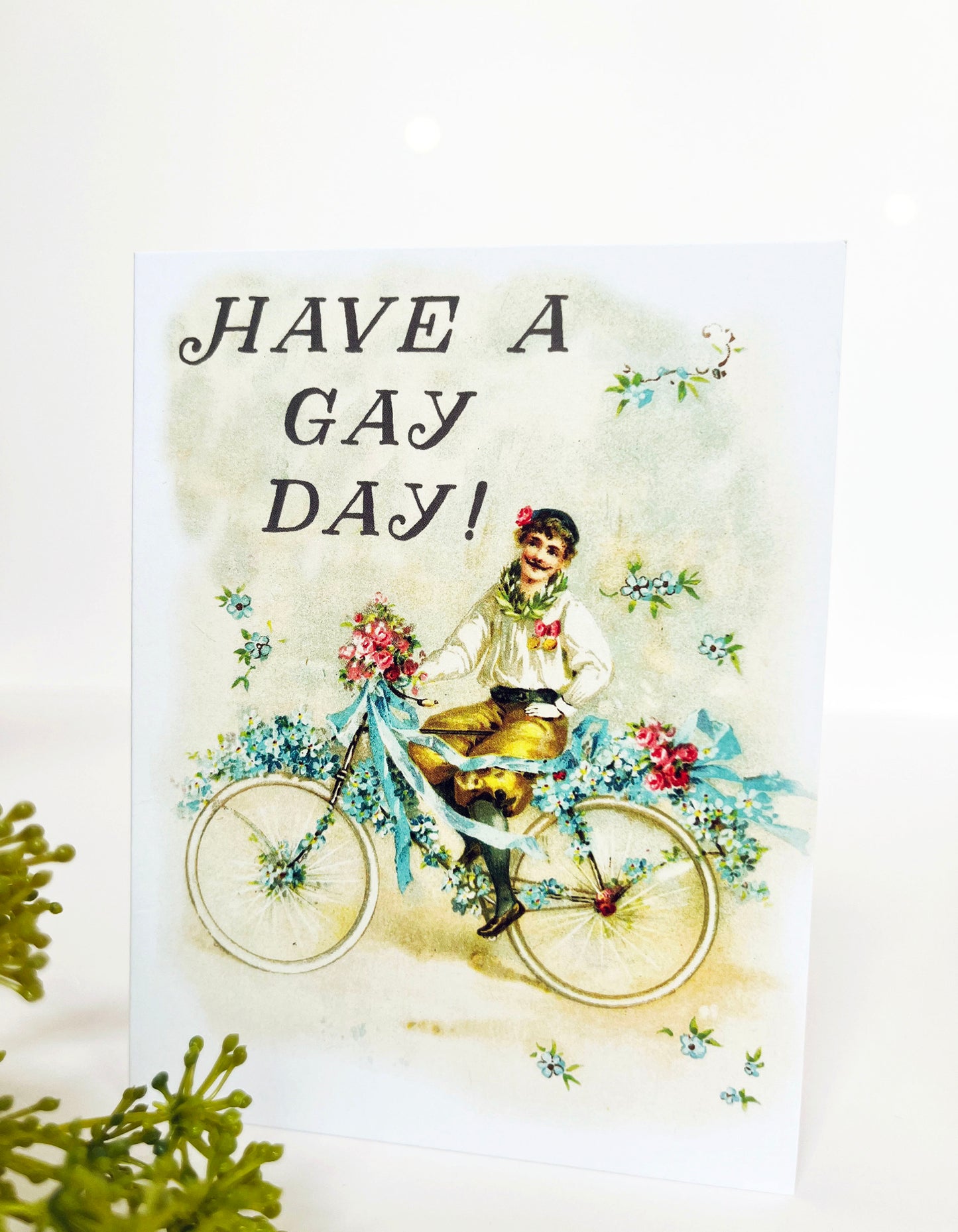 fun cute upbeat happy greeting card for celebration congratulations just because valentines day all purpose have a gay day with a man riding a bicycle bike vintage vibes pastel outdoor scene mustache stylish  bold colorful coin laundry 