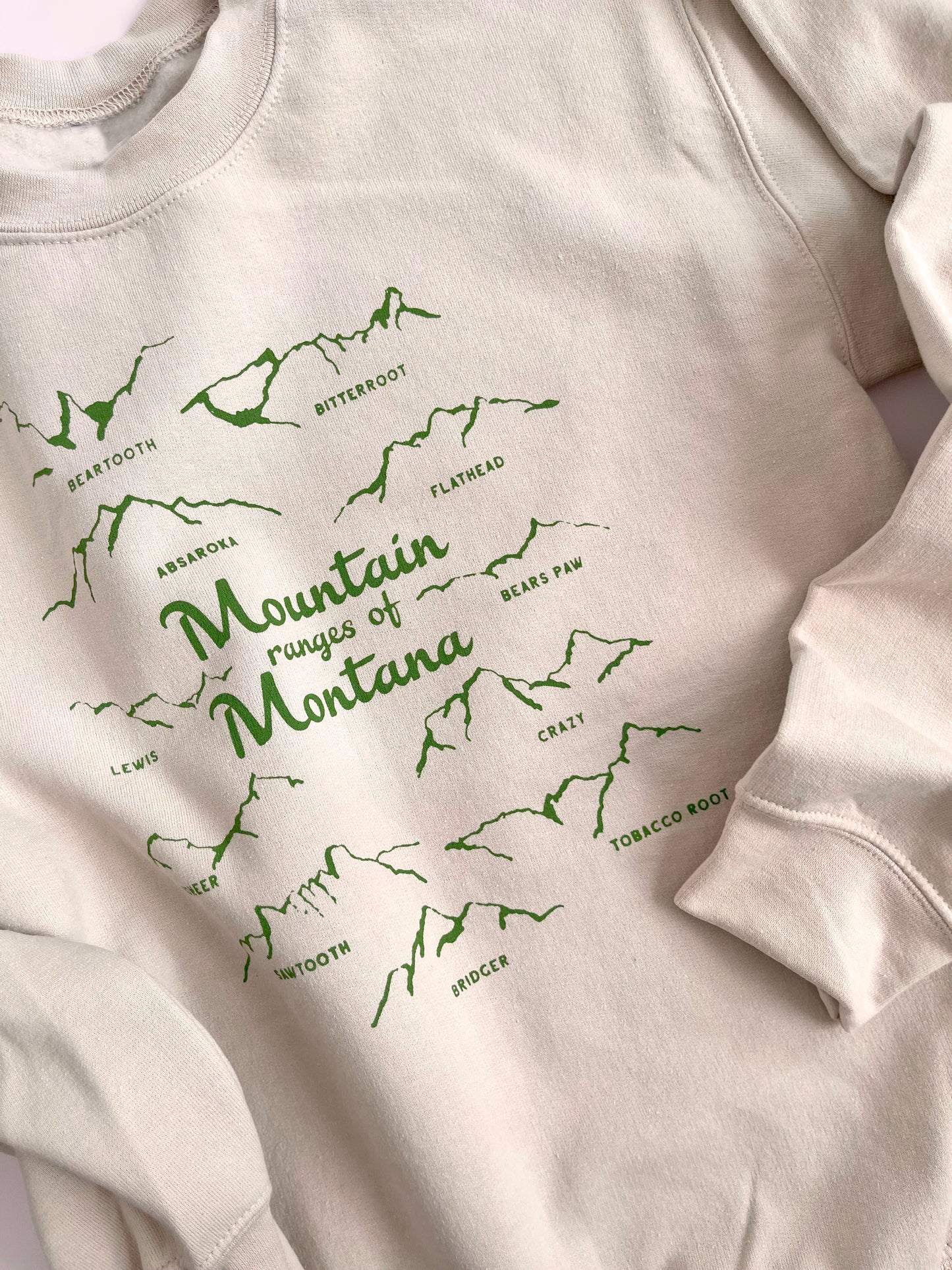 Mountain ranges of montana crew neck sweatshirt cream with green screen print bridger bozeman big sky missoula yellowstone glacier souvenir skier hiker adventure western fashion style hb elliot
