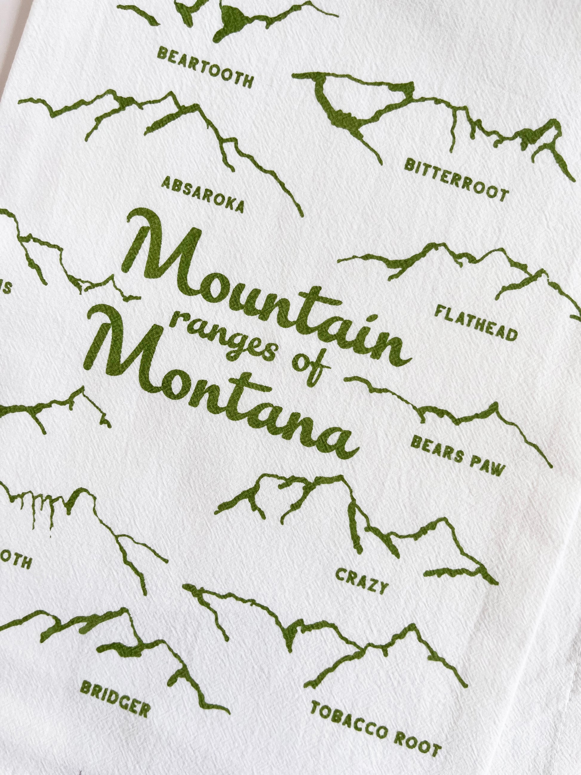 cotton tea towel with drawings of the mountain ranges of montana green screen print fun modern kitchen home decor coin laundry montana 