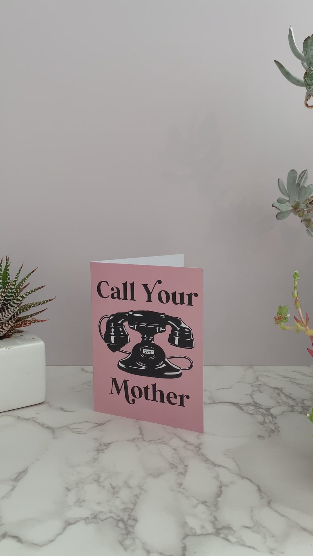 Pink greeting card with black vintage rotary telephone. Front says "Call Your Mother." Blank inside. retro style fun funny mother's day send to college student kid at camp adult child