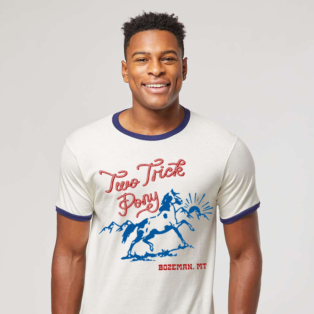 Man wearing a white t-shirt with red and blue graphics and text on a plain background