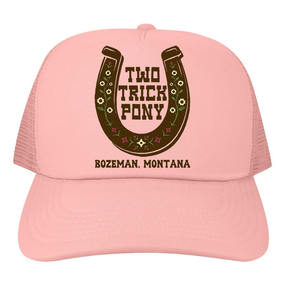 Pink trucker hat with a horseshoe design and text on a white background